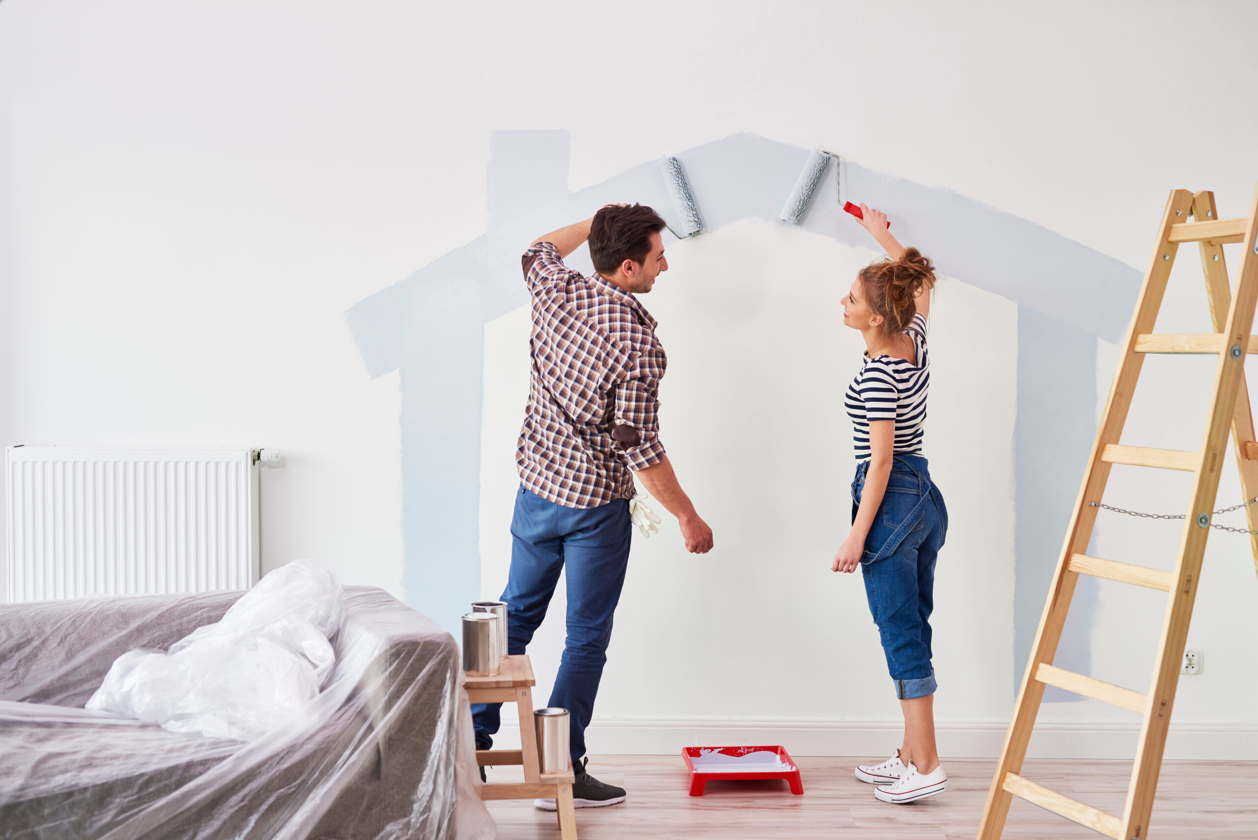 Young,Couple,Painting,The,Interior,Wall,In,Their,New,Apartment